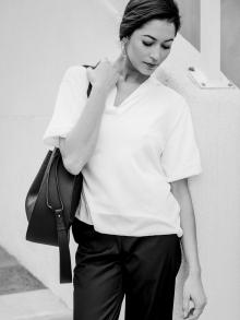 Female model standing by stair case looking down wearing clothing by The Row and Emanuela Duca earring