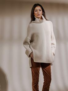 Model wearing white turtle neck sweater